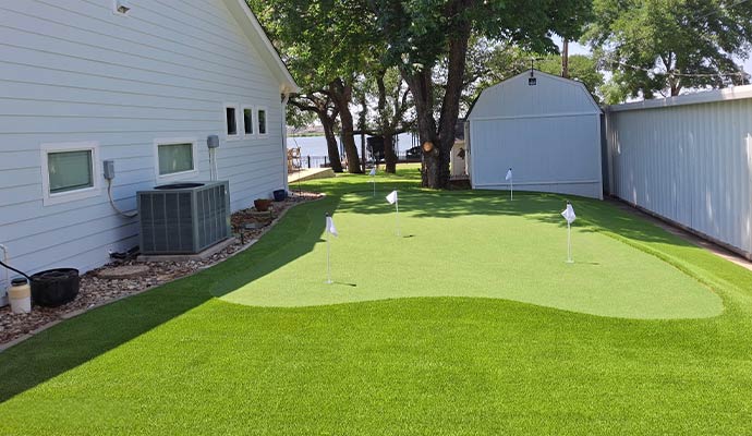 A custom residential backyard artificial grass putting green