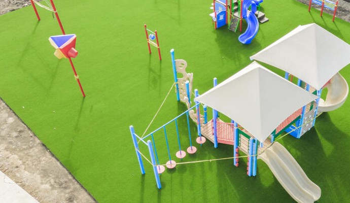 Playground featuring newly installed synthetic grass for children’s safety