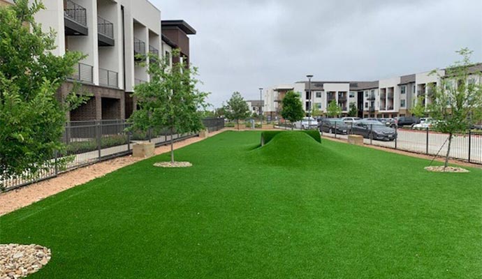 Multifamily community pet park with artificial turf mounds