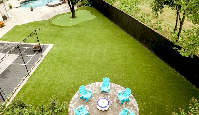 Backyard artificial turf lawn with putting green and fire pit