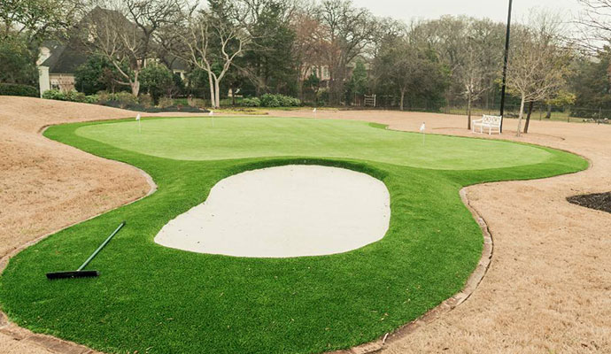 Backyard putting green with sand trap and rake