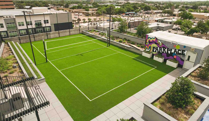 Commercial rooftop sports court with artificial turf, marked playing lines, and net