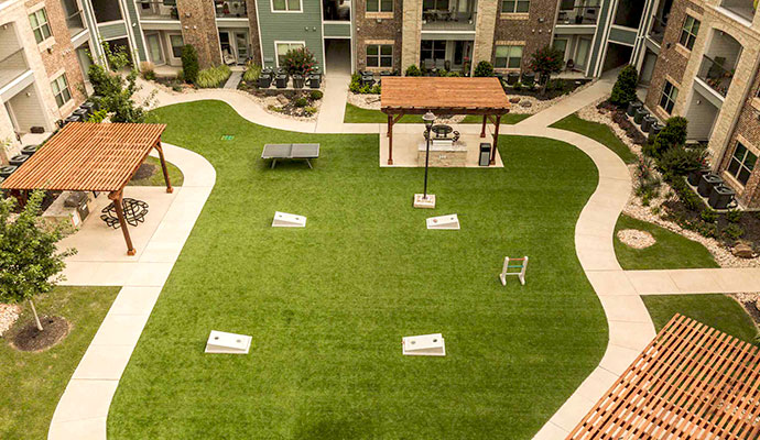 Apartment community courtyard with synthetic turf lawn and games