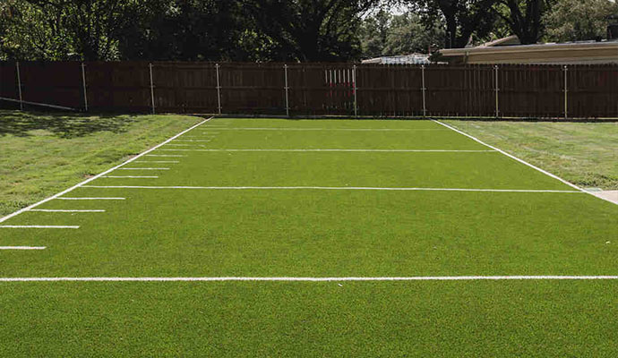 Backyard American football field with artificial turf.