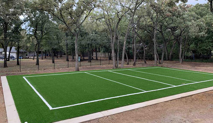 Backyard multi-sport court with artificial turf.