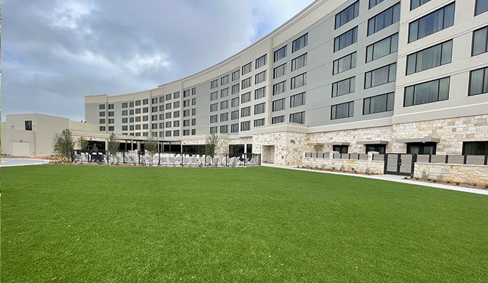 Commercial hotel building with green synthetic turf lawn