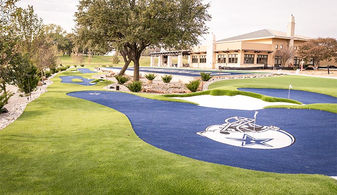 Blue artificial turf green with Cowboys star logo