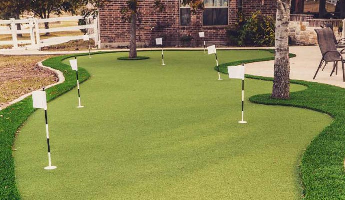 Custom artificial turf putting green installed in golf backyard