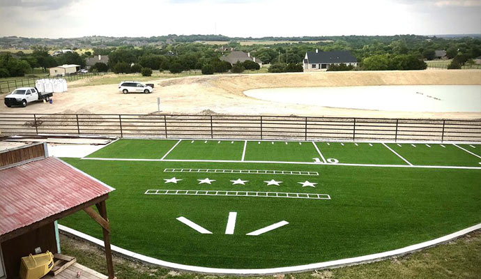 Custom football field with artificial turf on a large property