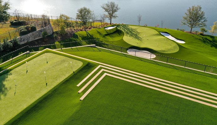 Custom multi-tiered residential backyard putting green with sand bunkers