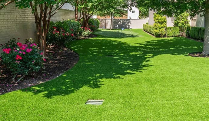 Outdoor drain cover set in green artificial turf backyard