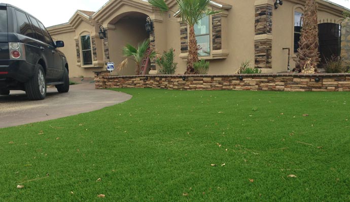 Installed turf with small debris in front of a house