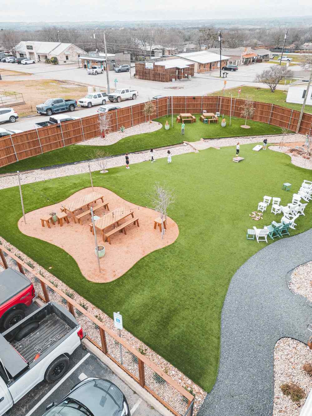 Bird’s-Eye View of Amenity Lawn with Cornhole and River Rock at Jake’s Burger in Aledo