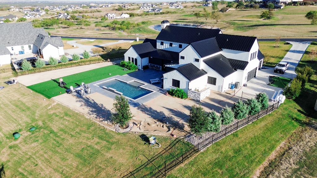 Aerial view of new pool construction landscaping featuring a custom backyard putting green and safe, clean poolside artificial turf, creating a versatile outdoor space for family fun and golf enthusiasts.