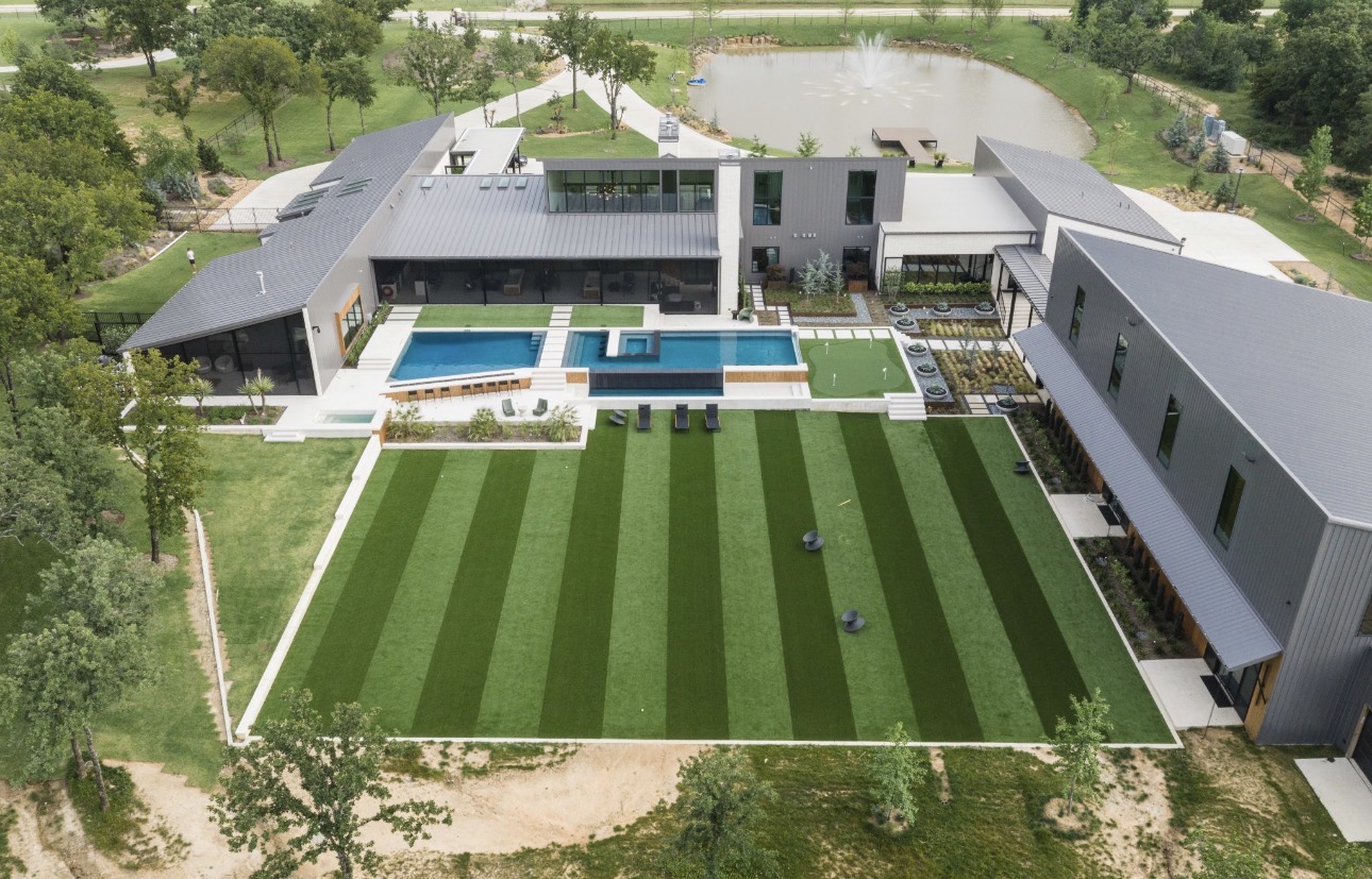 Custom putting green seamlessly integrated into a modern luxury outdoor space with an elevated pool, contemporary architecture, clean lines, and high-end finishes.