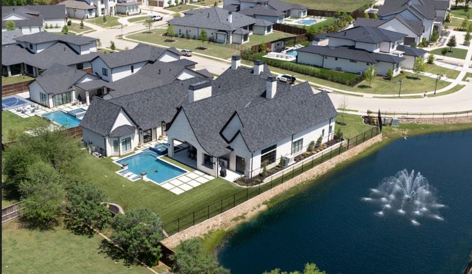 A stunning aerial view of a lakeside home and backyard