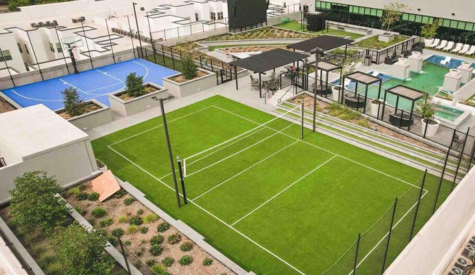 Rooftop amenity deck with a turf volleyball court and a pool.