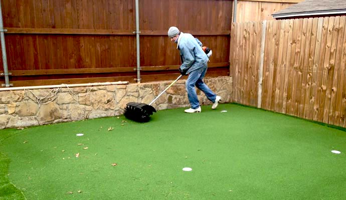 Debris removal from artificial turf putting green