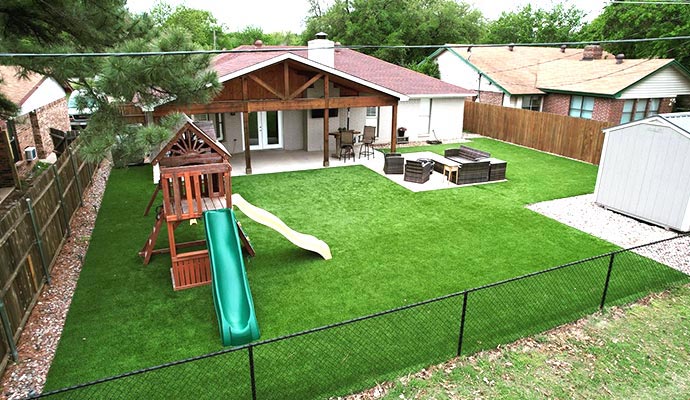 Residential backyard with installed synthetic turf in the playground area