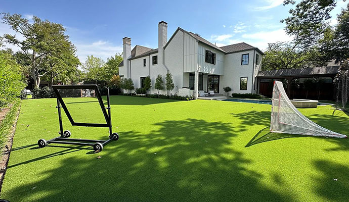 Residential backyard with artificial grass lawn and sports net