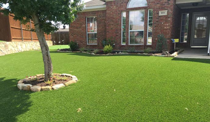 Residential front yard with a perfect artificial turf lawn.