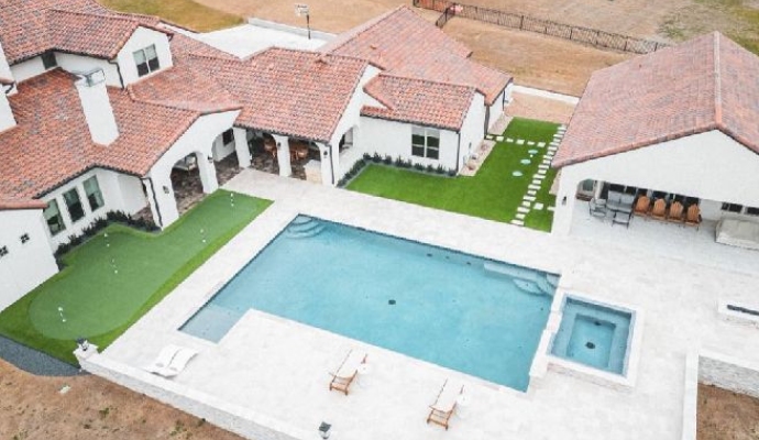Swimming pool and synthetic turf lawn in luxury home backyard