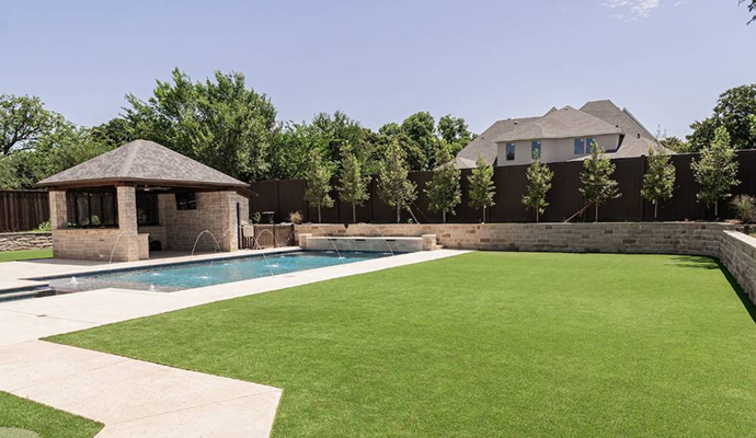 Lush synthetic grass installed neatly around a home swimming pool.