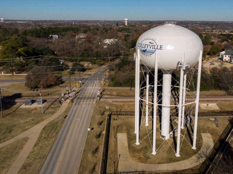 Colleyville, Texas white water tower on legs with Colleyville Artificial Grass in foreground.