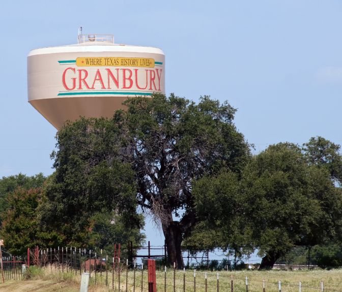 Granbury water tower surrounded by oak trees and Granbury Artificial Grass